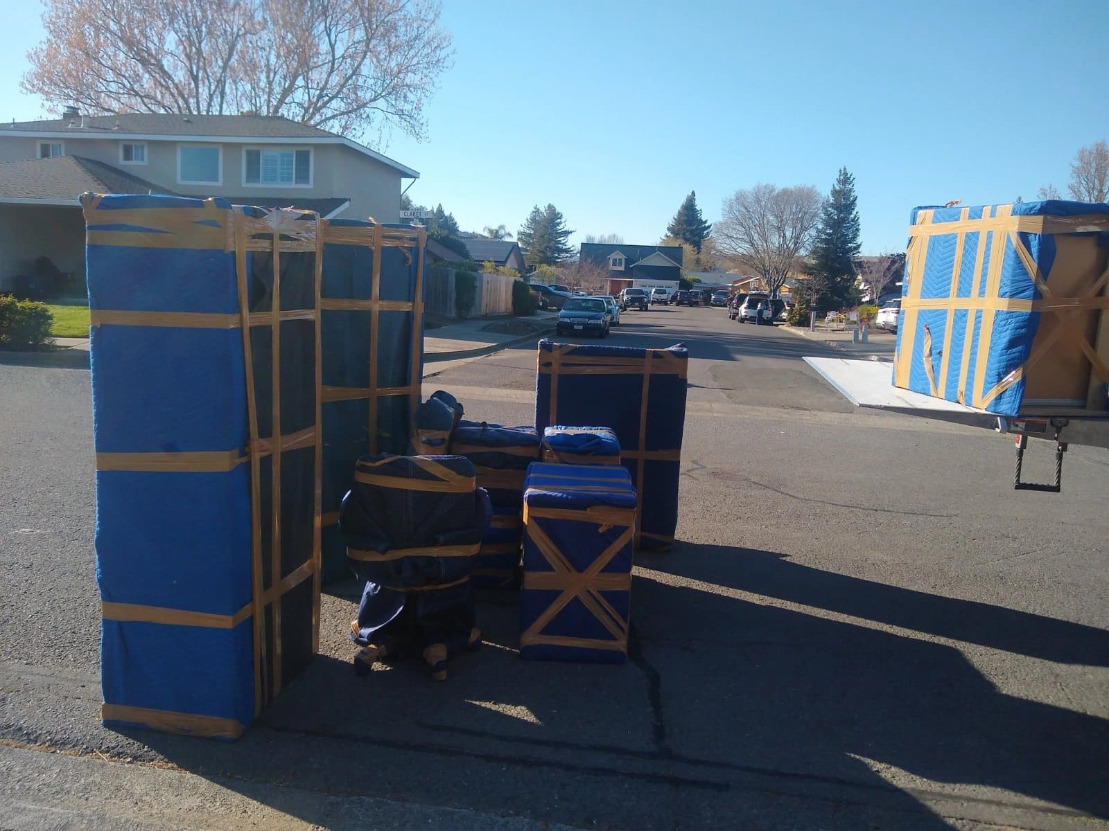 Blue and tan inflatable bounce house structures displayed in residential driveway
