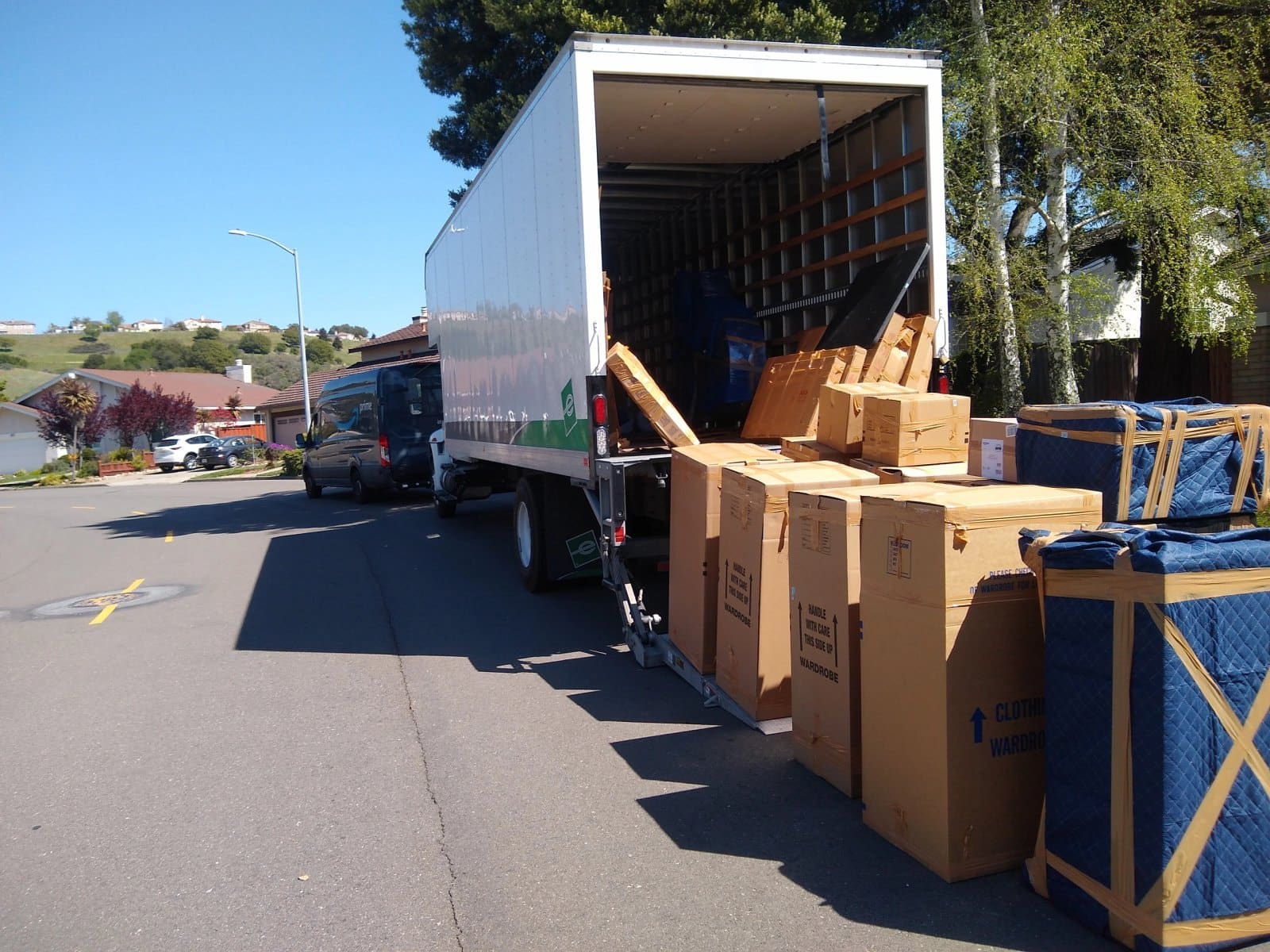 Moving truck loaded with cardboard boxes and furniture outside residential home