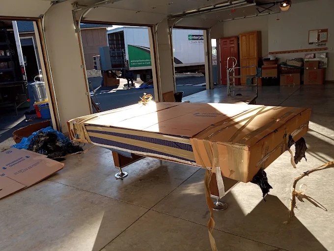 Billiard table with cover in spacious recreational facility with large windows and polished concrete floor