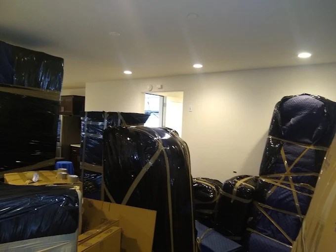 Storage room with black wrapped furniture and boxes secured with straps